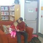 Father and daughter reading on couch